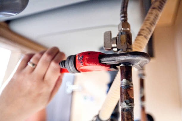 plumbing repair technician fixing leaking pipes inside Winfield home today
