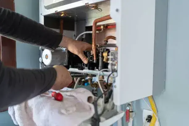 NexAir Home Services technician inspecting an electric tankless water heater in Scott Depot, WV. Tankless Water Heater Installation Near Me.