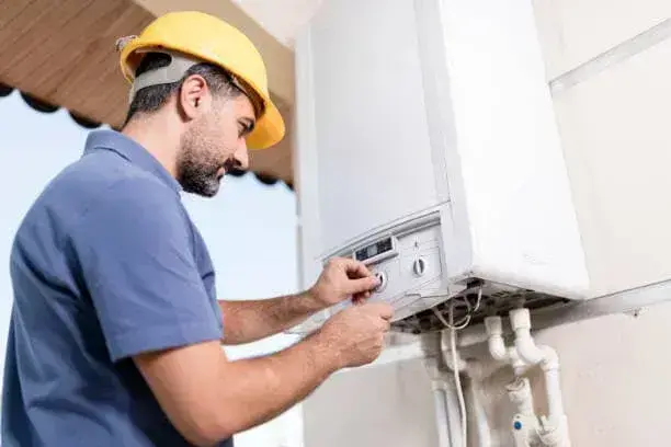 Technician checking service access around a tankless water heater in Fraziers Bottom, WV.